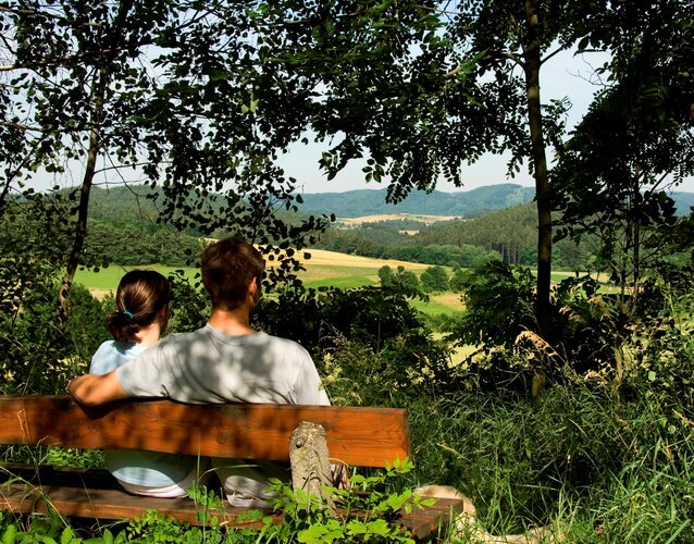 2 Personen auf Bank mit Blick in die Landschaft