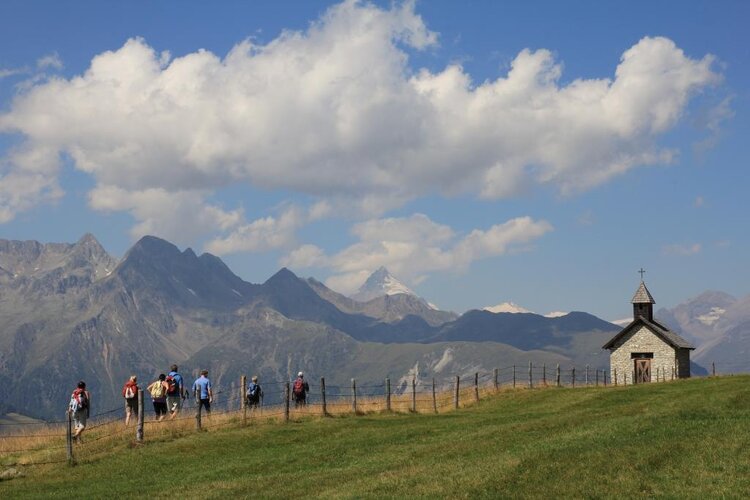 Eine Wandergruppe in einer hochalpinen Berglandschaft.