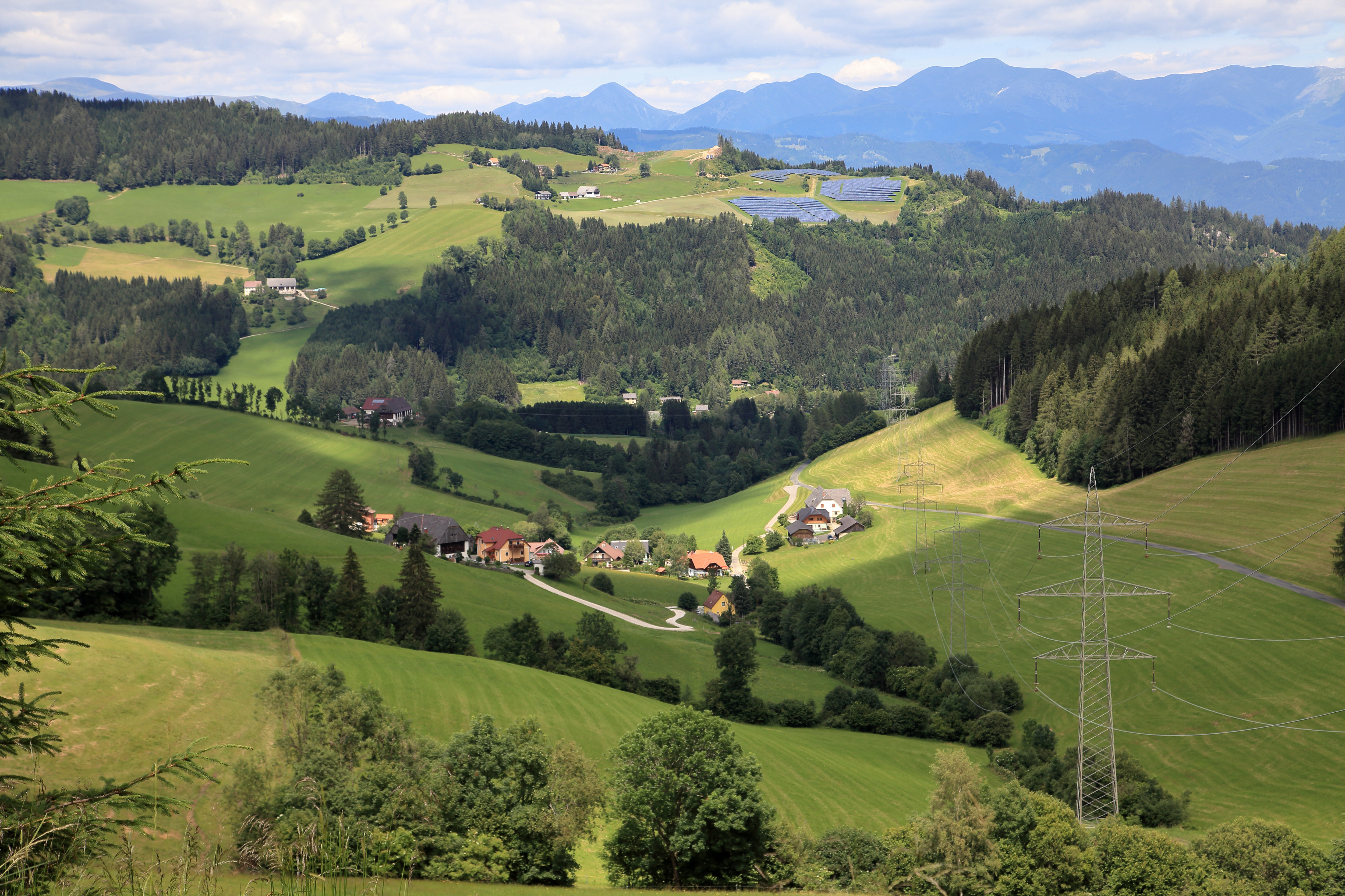 Häuser im Weitblick in hügeliger Landschaft